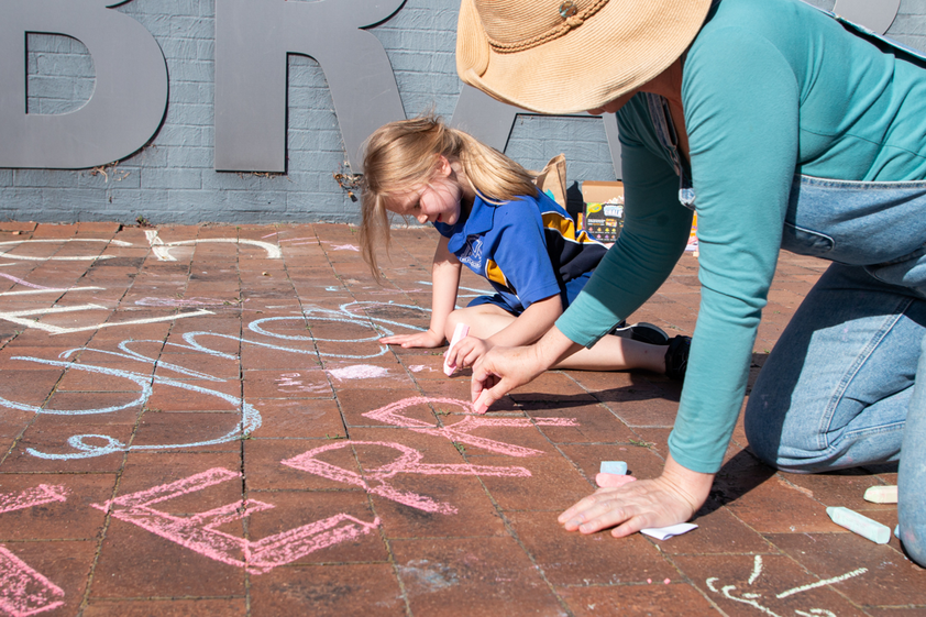 Chalk drawings with teacher and school child at Raymond Terrace